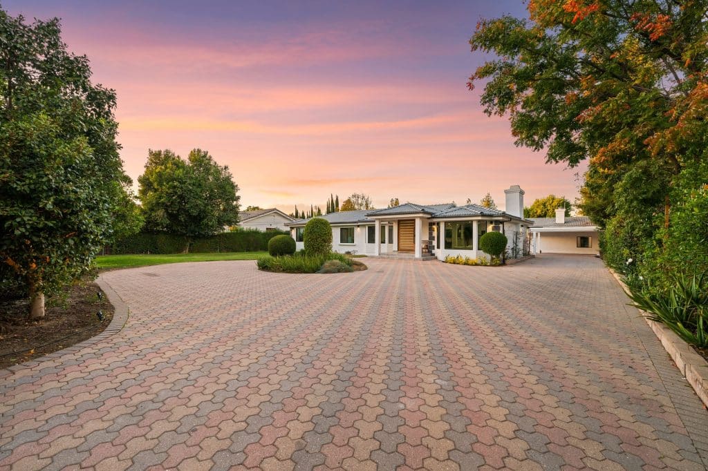 Modern suburban house with driveway at sunset.